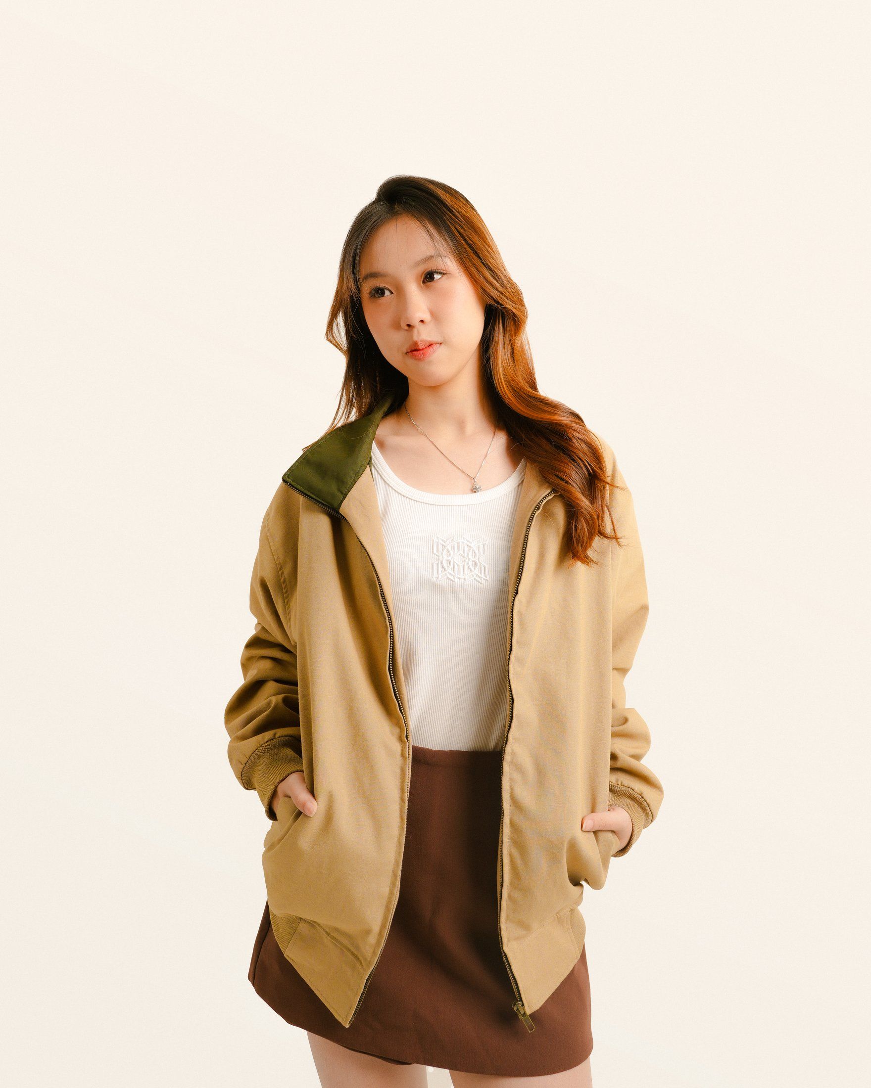 Model in the khaki zipper jacket with an olive collar, hands in pockets